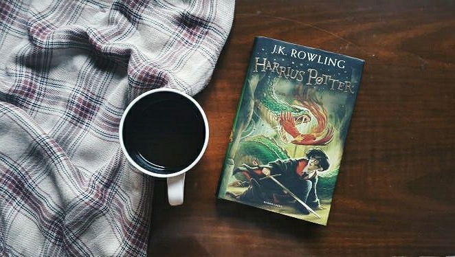 harry potter coffee book in latin next to wood and blankets translations